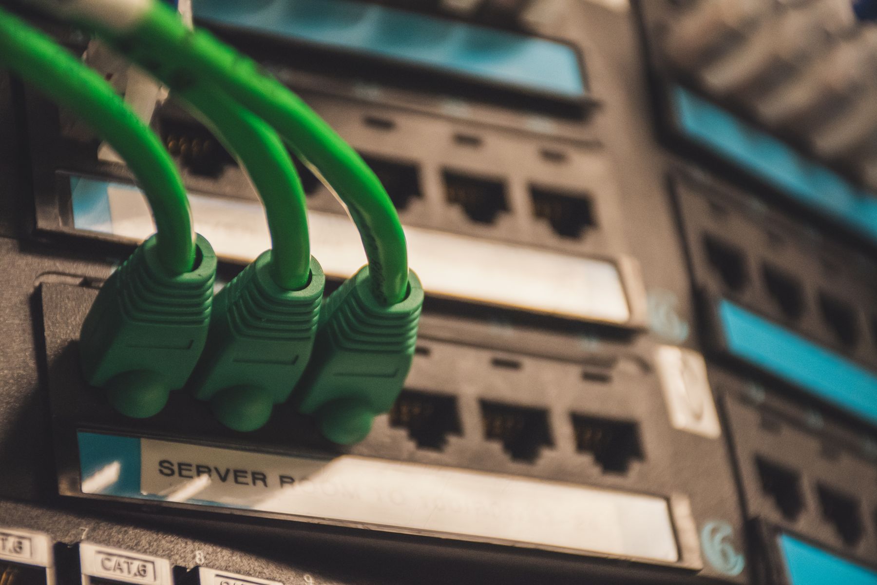Green network cables connected to labelled patch-panel ports.