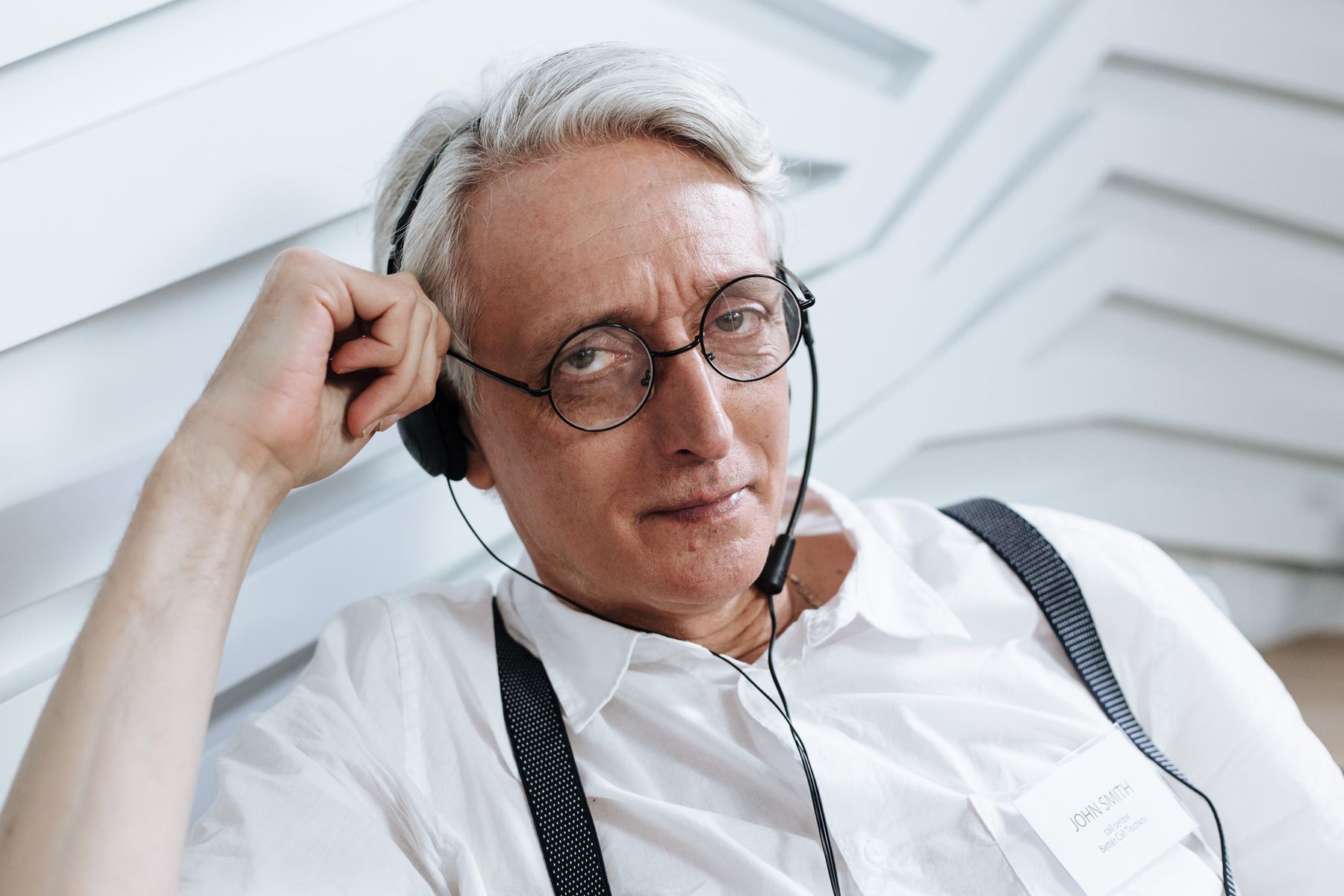 A professional wearing glasses and a headset.